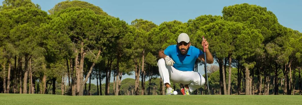 golf player aiming shot with club course